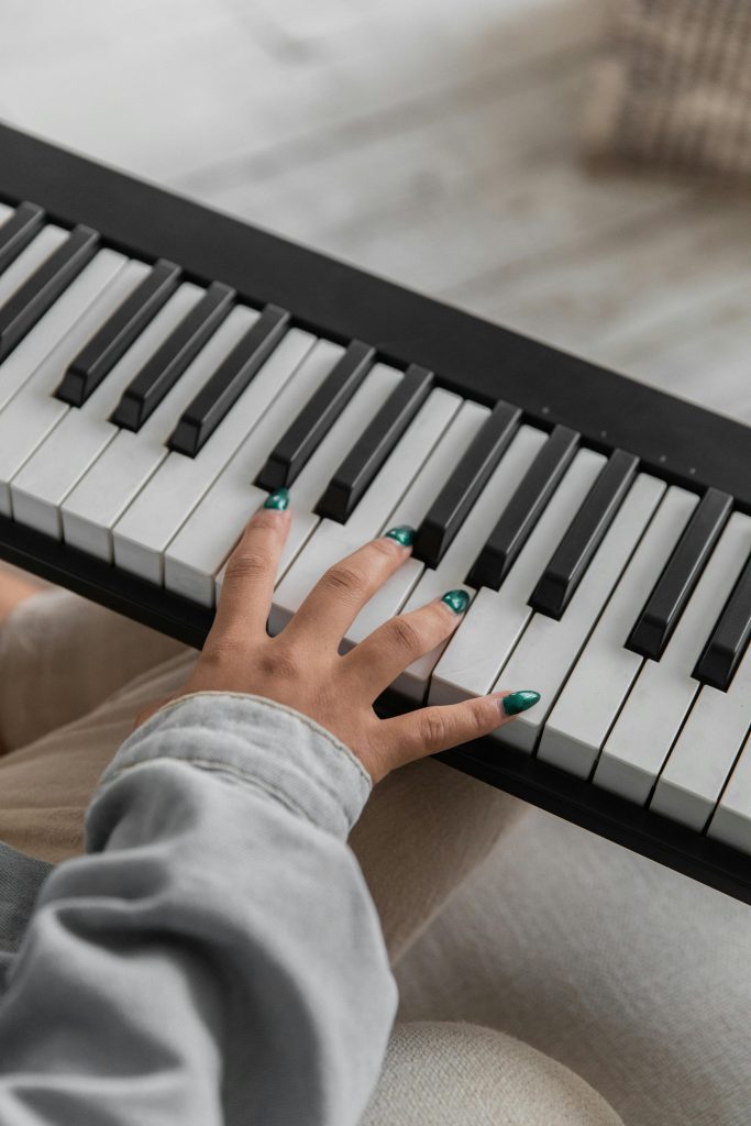 Close-up of a woman's hand playing piano keys, showcasing musical talent.